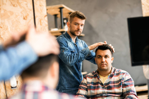 Mãos de um barbeiro o homem no processo de cortar cabelo ao cliente
 - Foto, Imagem