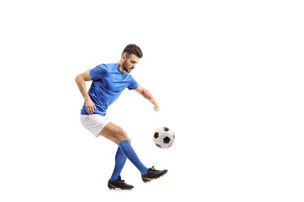 Soccer player juggling a football isolated on white background - Foto, afbeelding