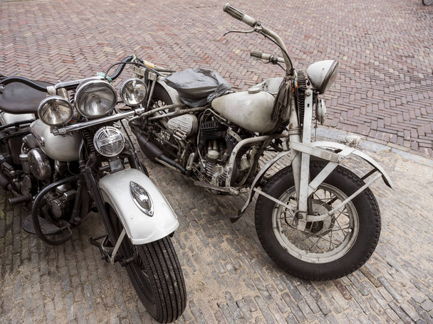 kaksi hyvin vanhaa Harley Davidson moottoripyörät vanhalla kadulla
 - Valokuva, kuva