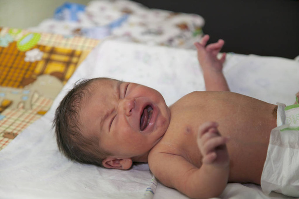 Yeni doğmuş bir bebek, bir yedi günlük eski bebek yatıyor ve değişen bir masada ağlıyor - Fotoğraf, Görsel