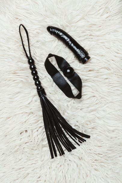 schwarze Lederpeitsche und Kugelknebel mit Dildo - Foto, Bild