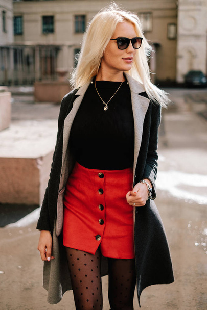 Fashion Girl In Fashionable Clothing. Beautiful girl in a coat and a red skirt. Posing In Street - Foto, afbeelding