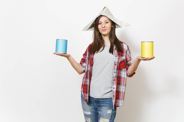 Young beautiful woman in casual clothes and newspaper hat holding paint tin cans isolated on white background. Instruments, accessories, tools for renovation apartment room. Repair home concept. - Photo, Image