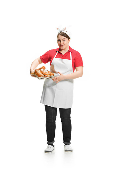 Portrait of cute smiling woman with pastries in her hands in the studio, isolated on white background - Foto, afbeelding