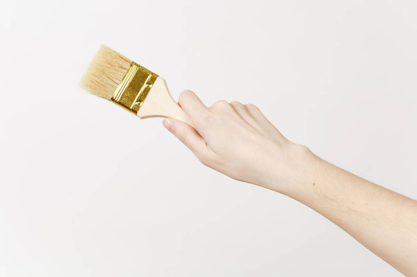 Close up of female hand horizontal holds paint brush isolated on white background. Instruments, accessories, tools for renovation apartment room. Repair home concept. Copy space for advertisement. - Foto, afbeelding