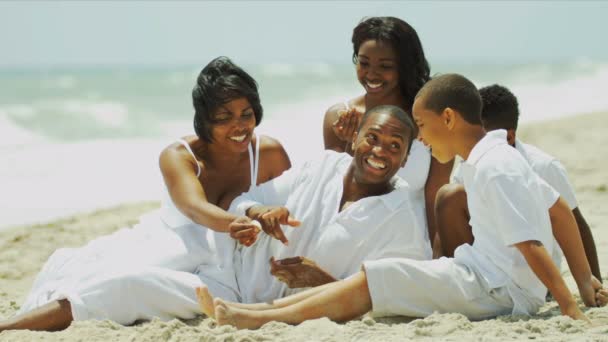 Família afro-americana desfrutando de tempo juntos falando praia
 - Filmagem, Vídeo