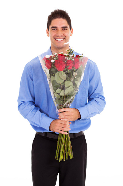 Young man with bunch of red roses on white - Foto, Imagen