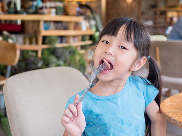 Asiática chica niño comiendo american desayuno
 - Foto, Imagen