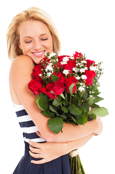 Pretty woman hugging bunch of red roses - 写真・画像