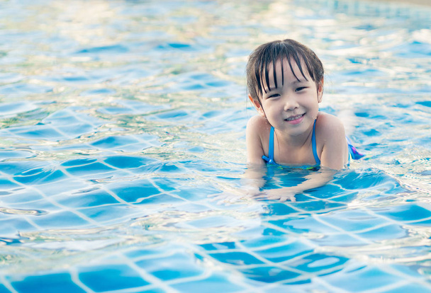 Azjatyckie dziewczyna bawi się w basenie, ustanawiające - Zdjęcie, obraz