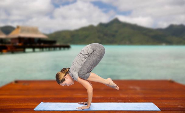 mulher fazendo ioga no guindaste posar no tapete ao ar livre
 - Foto, Imagem
