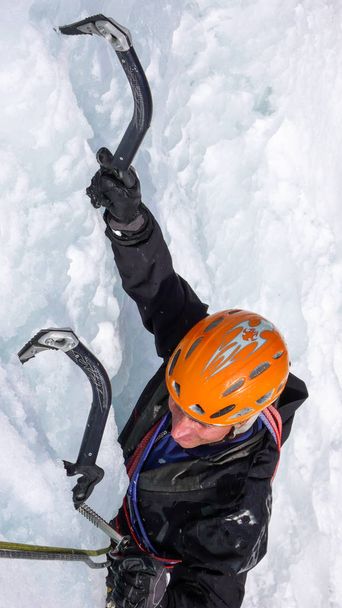 arrampicatore su una ripida cascata ghiacciata in una bella giornata invernale sulle Alpi svizzere
 - Foto, immagini