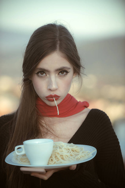Woman eating pasta as taster or restaurant critic. woman with italian pasta and tea or coffee - Photo, Image