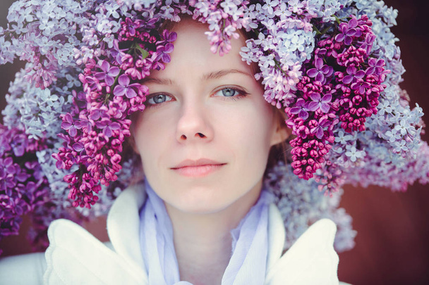 Outdoor fashion photo of a beautiful young blue-eyed woman. Spring color. beautiful blonde girl in lilac flowers. Perfume with a scent of flowers. Perfumes and beauty - Photo, Image