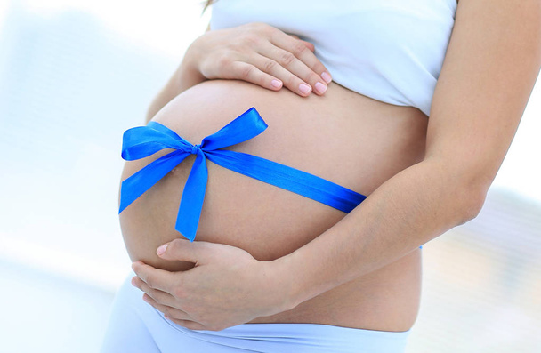 Happy pregnant woman measuring her tummy and waist. - Фото, зображення