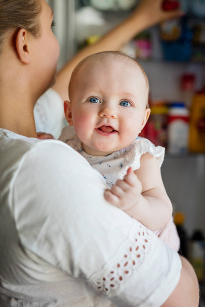 Şefkatli anne çalışma evine gülümseyen ve sevimli bebek kızla - Fotoğraf, Görsel