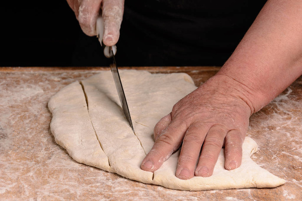 Cook průřezy Syrové těsto nožem na úzký řádek - Fotografie, Obrázek