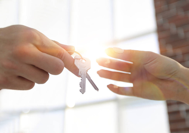 Cropped image of estate agent giving house keys to man in office - Foto, Bild