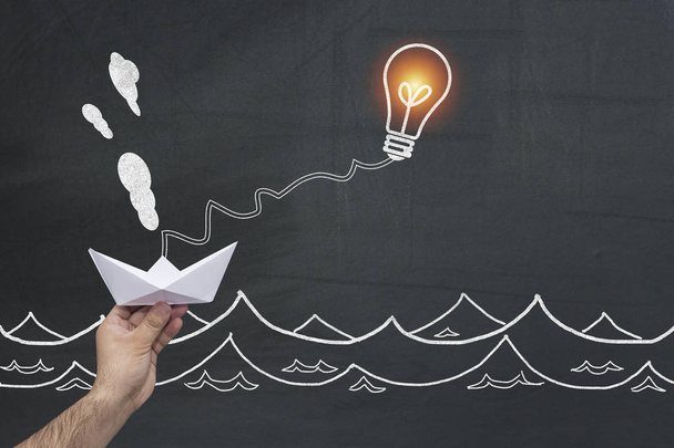 Бизнес инновационное решение и творческая концепция. лампочка или лампочка делает перемещение бумажная лодка как успешная метафора для умного мышления решения экономических и транспортных проблем
. - Фото, изображение