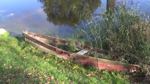 złamane drewnianej łodzi, w pobliżu rzeki jesień - Materiał filmowy, wideo