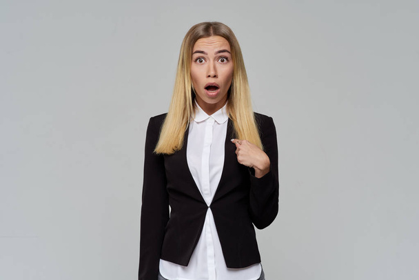 business cute blonde woman with a shocked face opens her mouth and eyes wide in surprise and points at herself with her finger.  - Фото, зображення