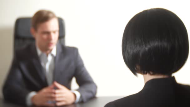 stellt ein Mann im Anzug einer brünetten Frau in einem Interview Fragen. 4k. Interview. Rekrutierung - Filmmaterial, Video