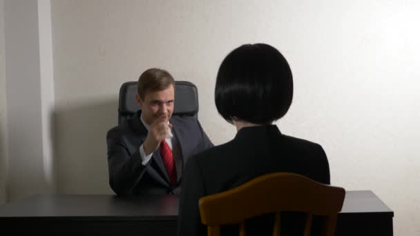 ένας άνθρωπος σε ένα κοστούμι θέτει ερωτήματα σε μια μελαχρινή γυναίκα σε μια συνέντευξη. 4 k. συνέντευξη. προσλήψεις - Πλάνα, βίντεο