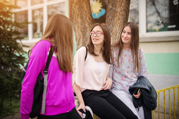 tres hermosas chicas de secundaria con mochilas hablando
  - Foto, imagen