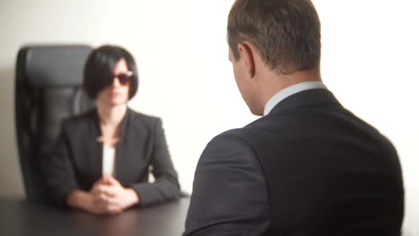 eine brünette Frau im Anzug stellt einem Mann in einem Interview Fragen. 4k. Interview. Rekrutierung - Filmmaterial, Video