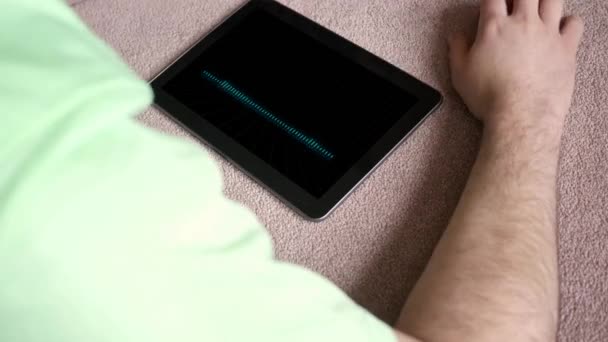 Een man luistert naar een afspeellijst van generieke nep app op zijn tablet - digitale golfvorm versie - Video