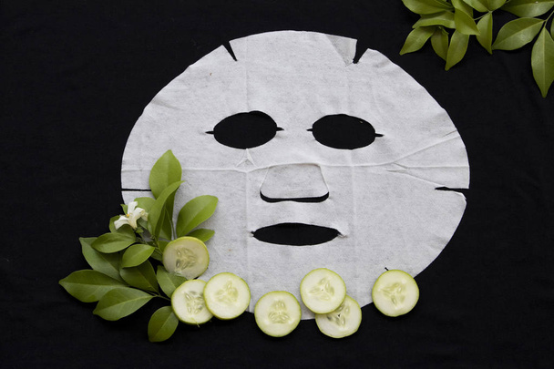 natural sheet mask health care for skin face brightening from cucumber on background black - Photo, Image