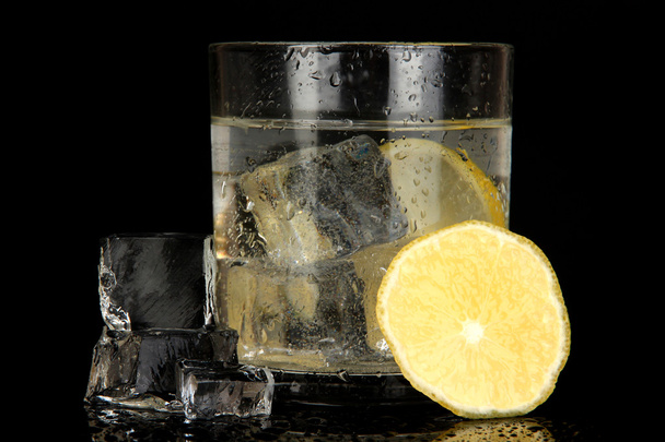Ice cubes in glass with lemon isolated on black - Foto, Imagen