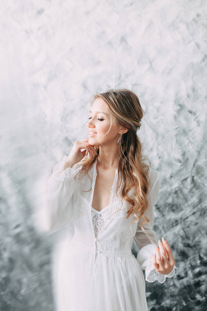 Beautiful young bride in boudoir dress on canvas background with paint. Wedding trends and ideas 2018, spring inspiration. Wedding in the Studio - Foto, afbeelding