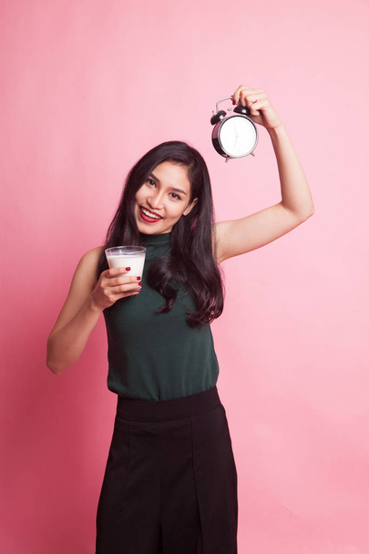 Healthy Asian woman drinking  glass of milk hold clock. - Фото, зображення