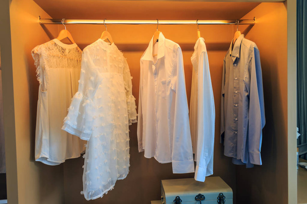 White lady shirts and whith shirts and gray shirt hanging on woo - Valokuva, kuva