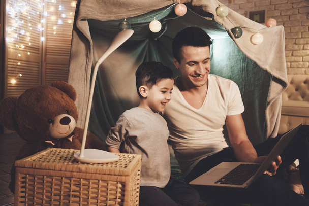 Father and son watching movie on laptop on couch at home - Foto, Imagem