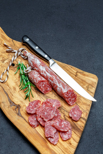 Dried organic salami sausage on wooden cutting board - Photo, image