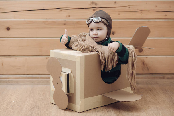 cardboard plane, childhood, little boy pilot. - Foto, imagen