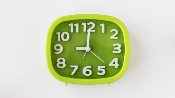 grüne Uhr mit weißen Ziffern und Pfeilen auf weißem Hintergrund, Zeitraffer - Filmmaterial, Video