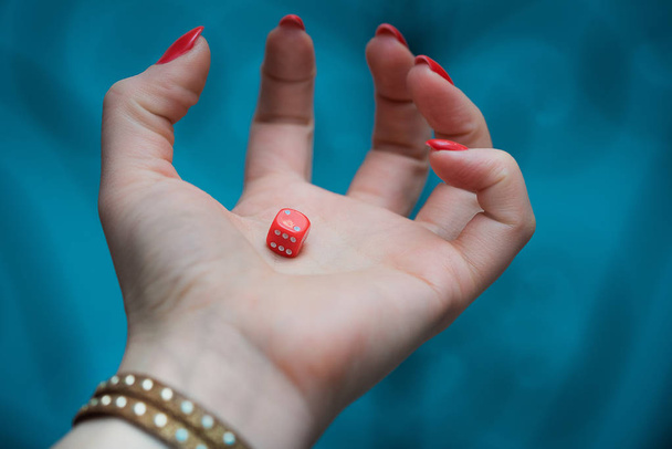 Red dice in womans hand at the blue background - Photo, Image