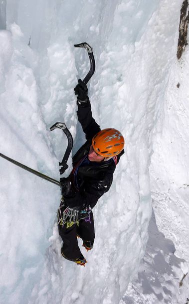 αρσενικό πάγο ορειβάτης στις απότομες παγωμένου καταρράκτη σε μία όμορφο χειμώνα ημέρα στις Ελβετικές Άλπεις - Φωτογραφία, εικόνα