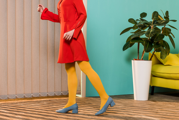 cropped shot of woman in bright clothing standing at colorful room, doll house concept - Foto, afbeelding