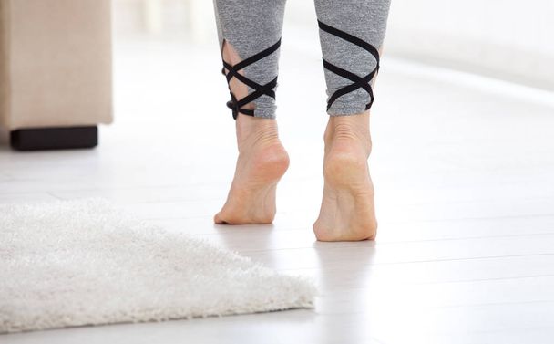 Warm floor concept. Closeup of female legs stepping by hardwood floor at home - Fotoğraf, Görsel