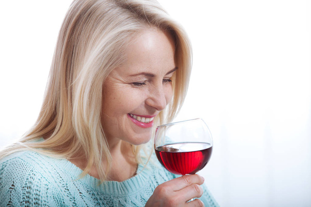 Happy blonde drinking red wine with eyes closed. - Фото, зображення