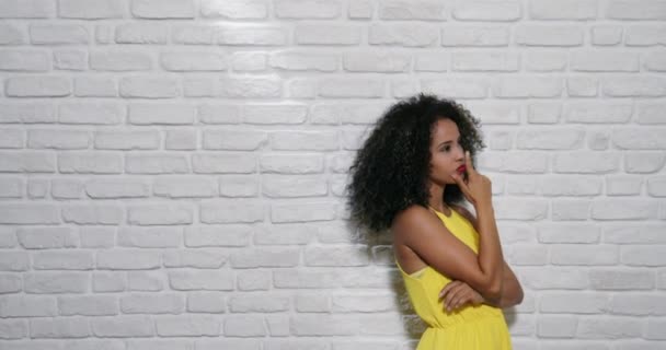 Expresiones faciales de la joven mujer negra en la pared de ladrillo
 - Imágenes, Vídeo