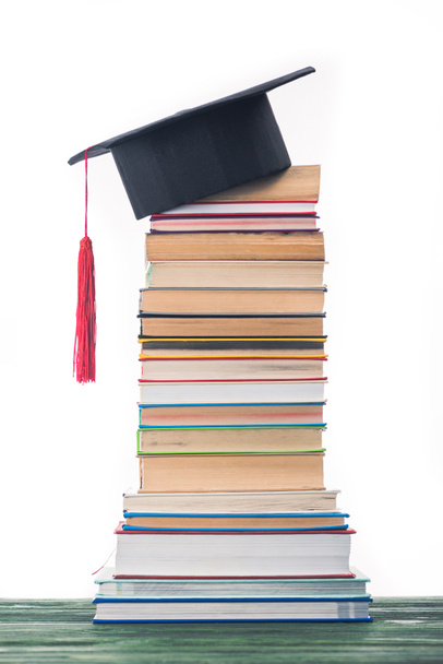 Graduation concept with stacked books and graduation hat - Fotografie, Obrázek