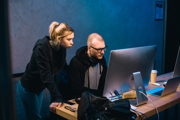 jovem casal de hackers olhando para tela do computador juntos
 - Foto, Imagem