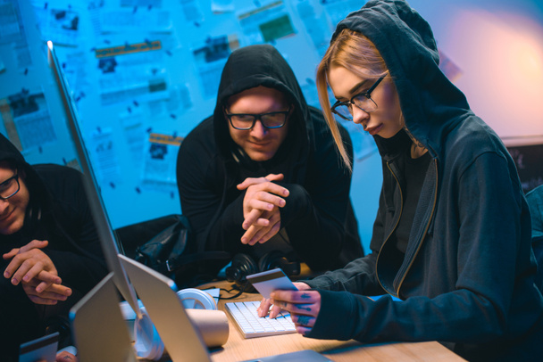 pareja joven de hackers con tarjeta de crédito robada en el lugar de trabajo
 - Foto, imagen