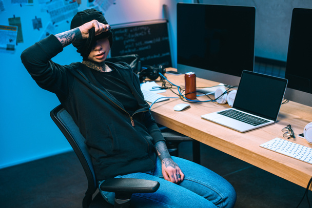 joven hacker en el lugar de trabajo quitándose la máscara
 - Foto, imagen