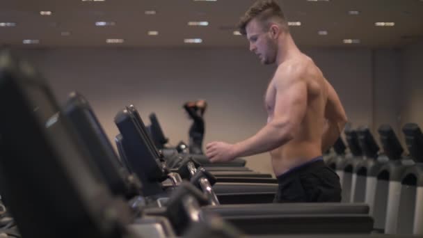 Man using screen treadmill for configuring program cardio exercise and running - Záběry, video